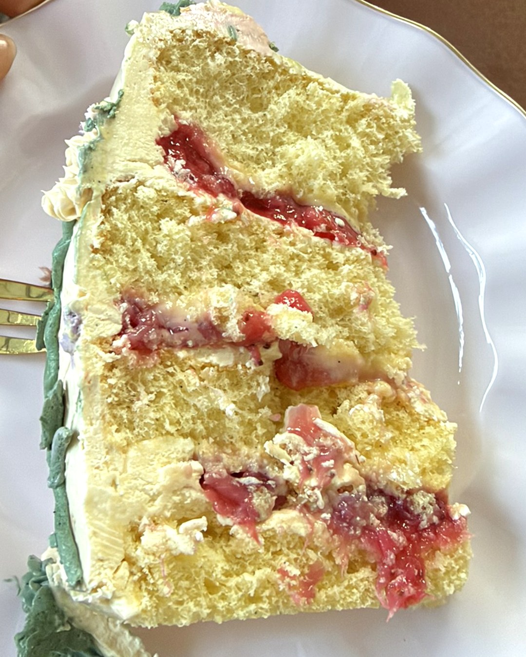 A slice of cake showing fluffy layers and strawberry filling