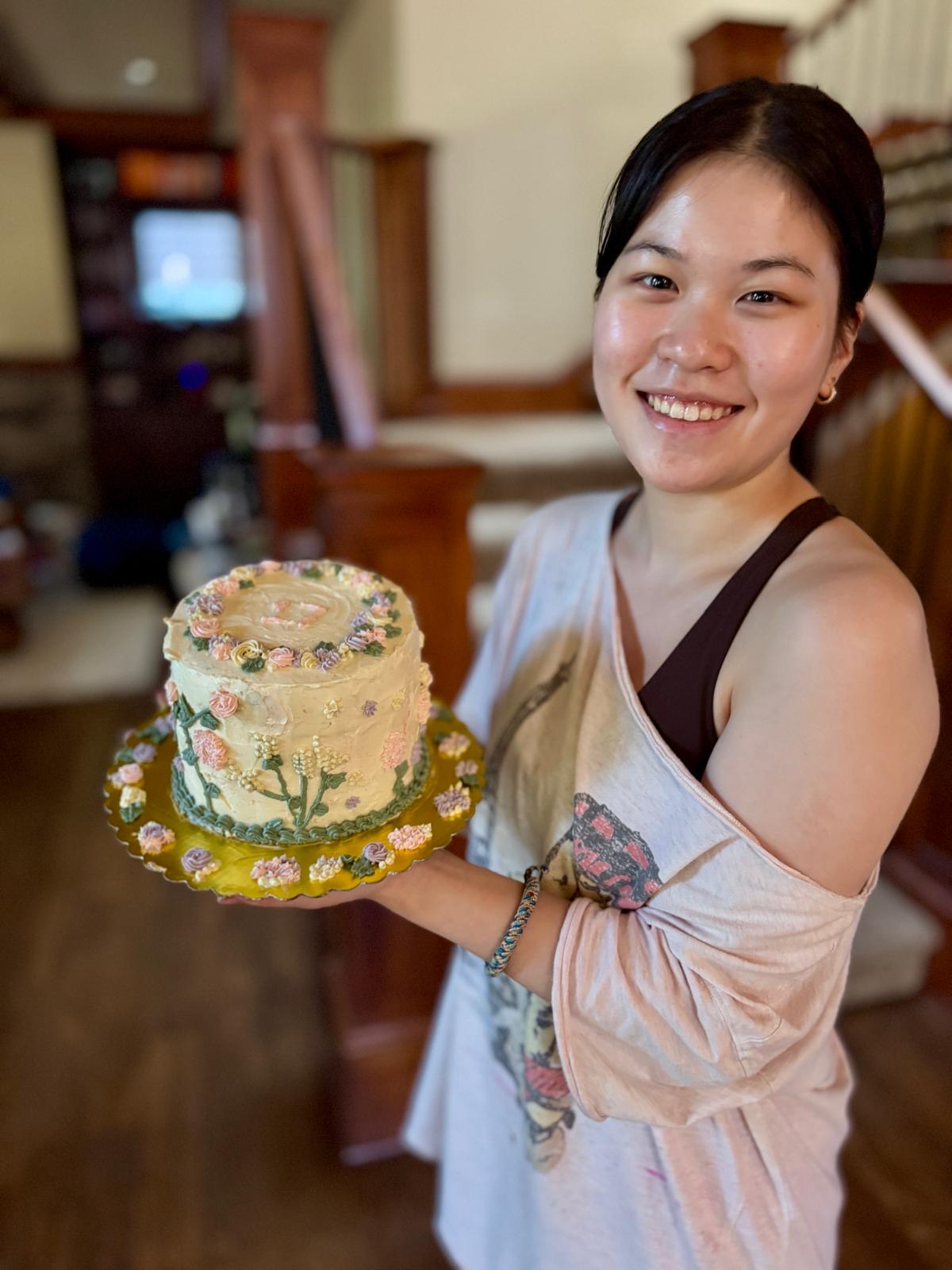 Zoe holding one of her hand-decorated floral cakes